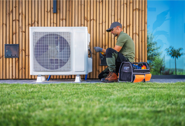an HVAC worker performing service on an air conditioning unit.