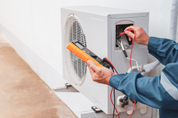 Air conditioner technician repairing central air conditioning system with outdoor tools.